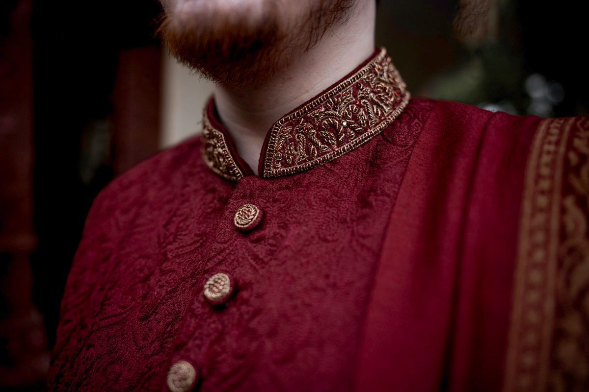 Close-up detail of the groom's embroidered collar and buttons on his maroon sherwani, Adam & Sobia's wedding at Chamba House, Lahore