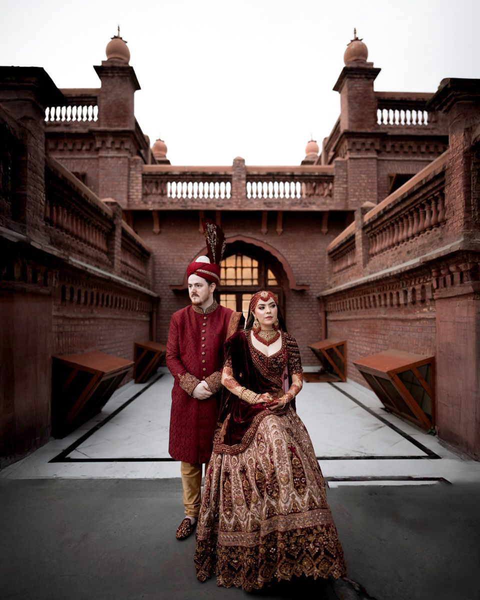 Bride and groom standing together between the two brick towers, Adam & Sobia's wedding at Chamba House, Lahore