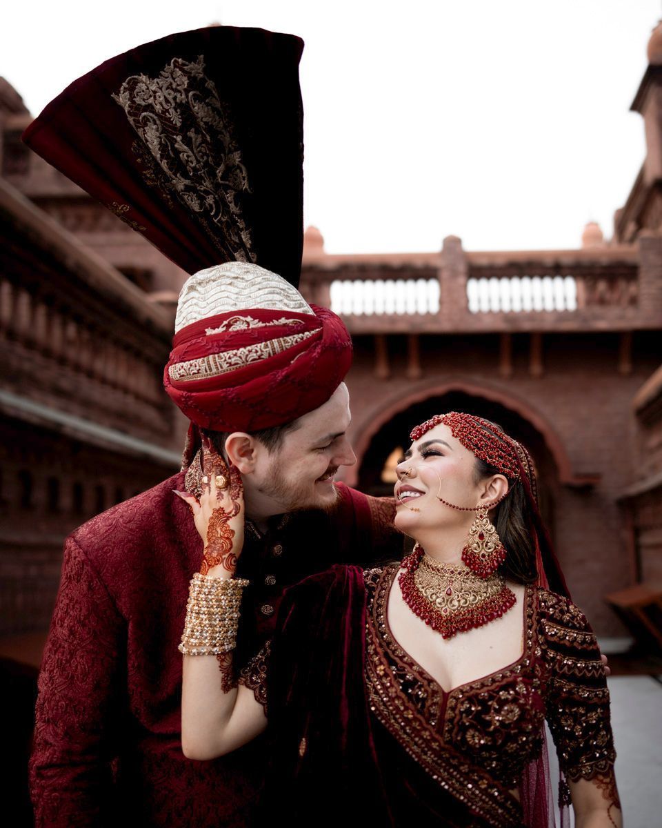 Bride and groom touching foreheads and smiling beneath a brick archway, Adam & Sobia's wedding at Chamba House, Lahore