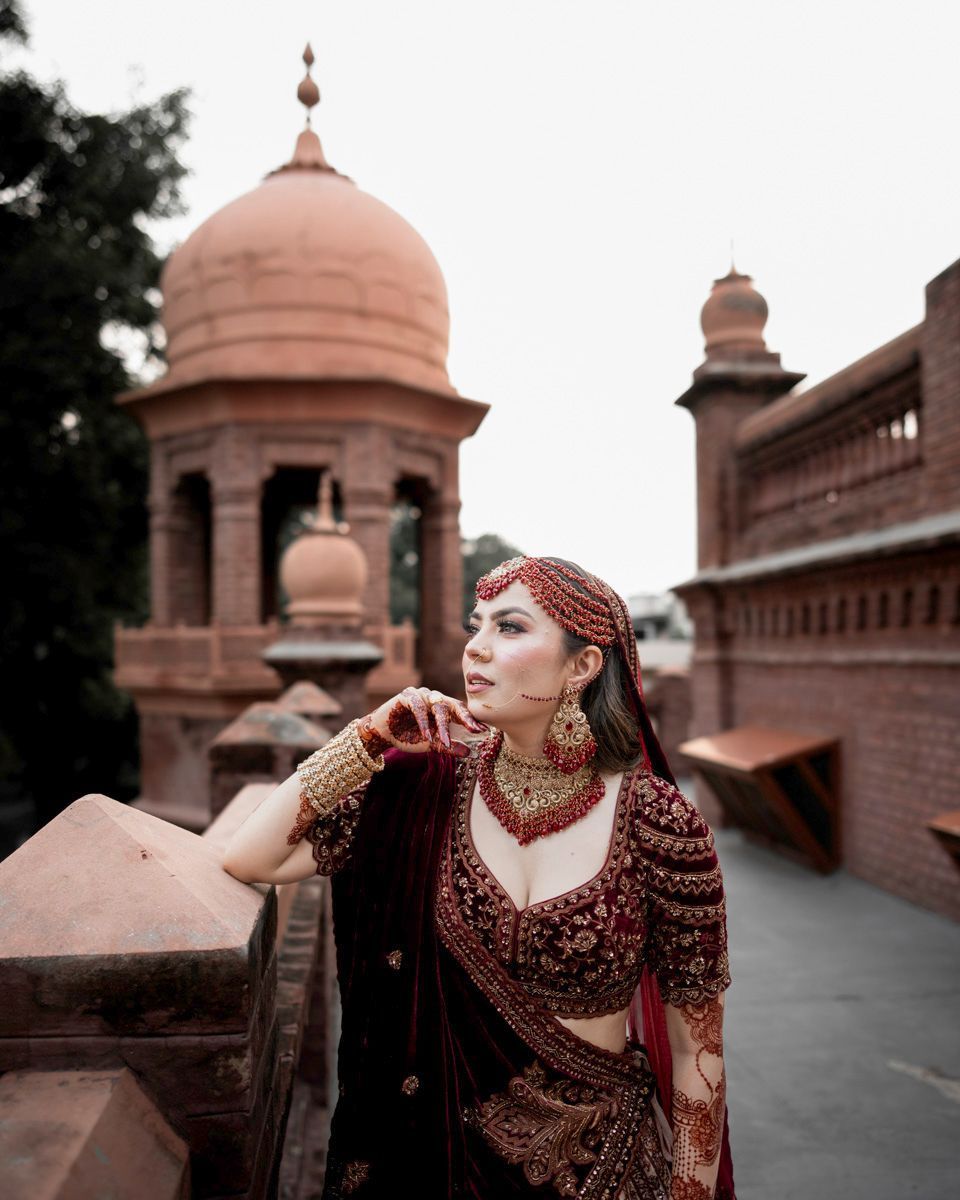 Solo bridal portrait leaning against the brick balustrade, looking off to the side, Adam & Sobia's wedding at Chamba House, Lahore