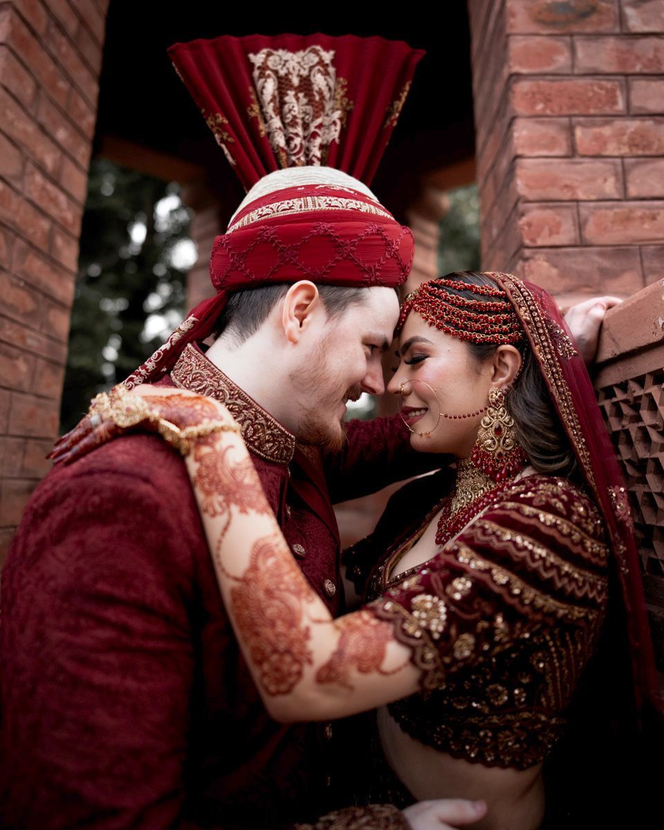 Close-up of bride and groom touching foreheads, her henna-painted hand on his shoulder, Adam & Sobia's wedding at Chamba House, Lahore