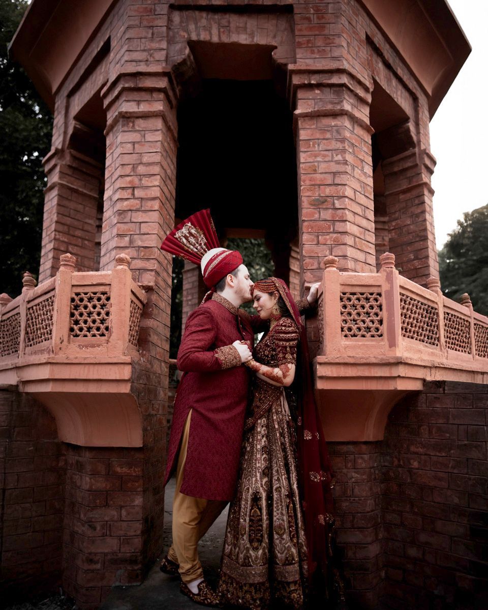 Bride and groom embracing inside a brick domed pavilion, Adam & Sobia's wedding at Chamba House, Lahore
