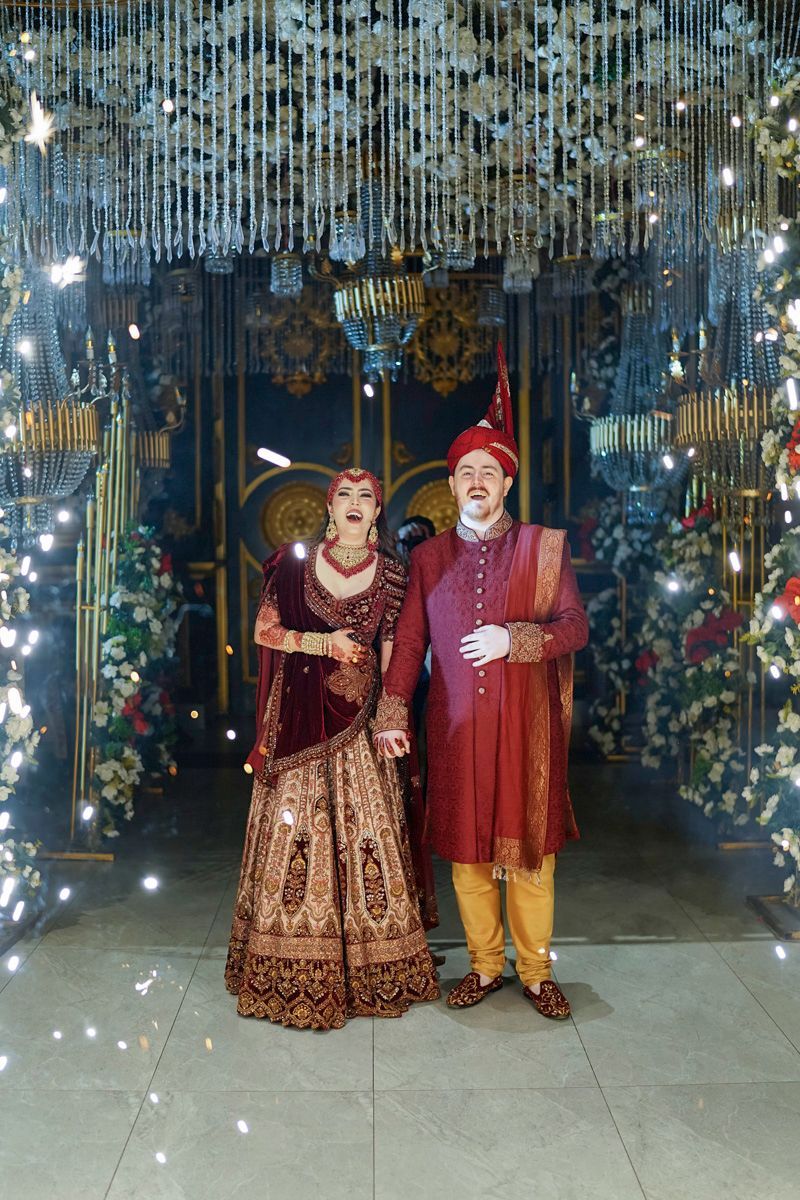 Bride and groom laughing together beneath a sparkling chandelier installation at the reception, Adam & Sobia's wedding