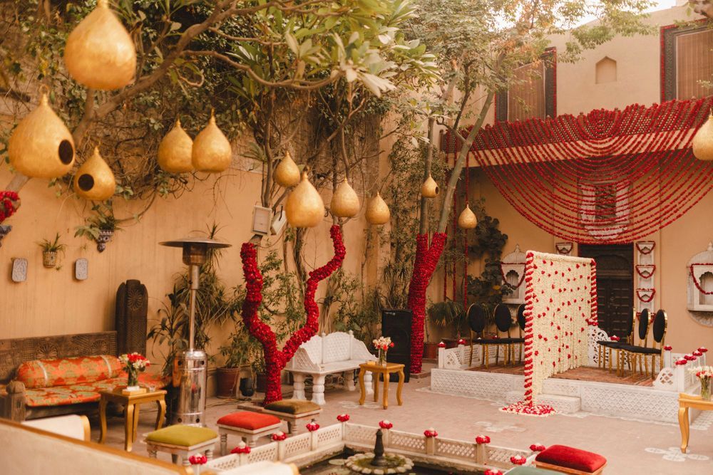 Wide shot of the haveli courtyard decorated with red and white floral garlands for the nikah, Ahmed & Laraib's wedding at Barood Khana Haveli, Lahore