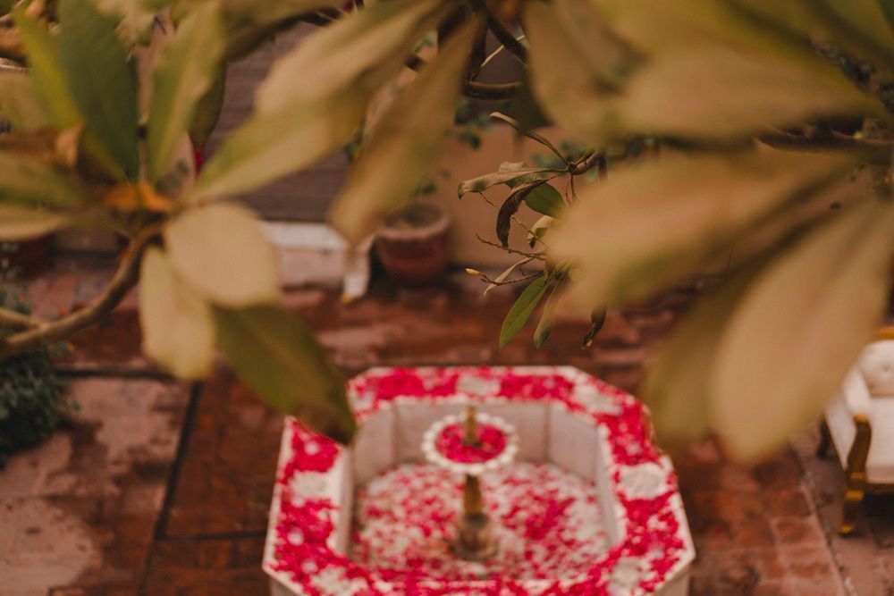 Detail of a marble fountain filled with red and white flower petals, Ahmed & Laraib's wedding at Barood Khana Haveli, Lahore