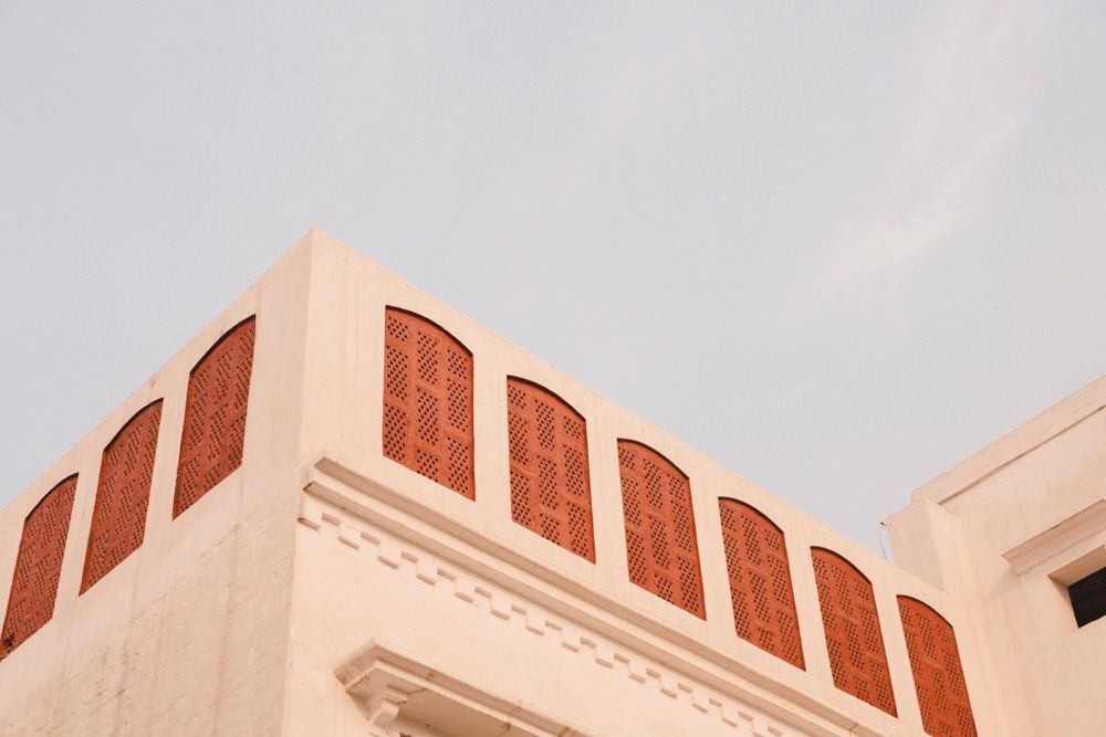 Close-up of the haveli's corner with red sandstone perforated window screens, Ahmed & Laraib's wedding at Barood Khana Haveli, Lahore