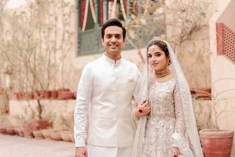 Bride and groom standing close together and smiling outdoors at the haveli, Ahmed & Laraib's wedding