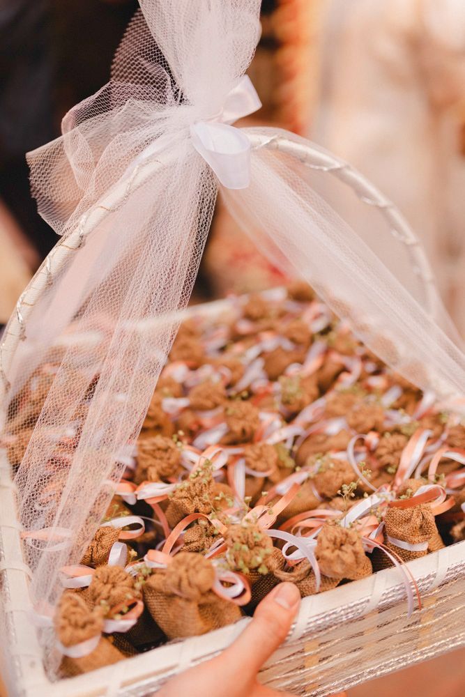 Detail of decorated wedding favor sachets tied with ribbons in a gift basket, Ahmed & Laraib's wedding