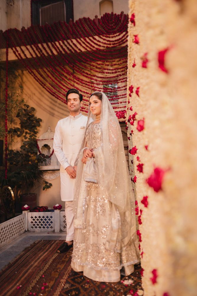Bride and groom standing together beside the marigold garland curtain after the nikah, Ahmed & Laraib's wedding