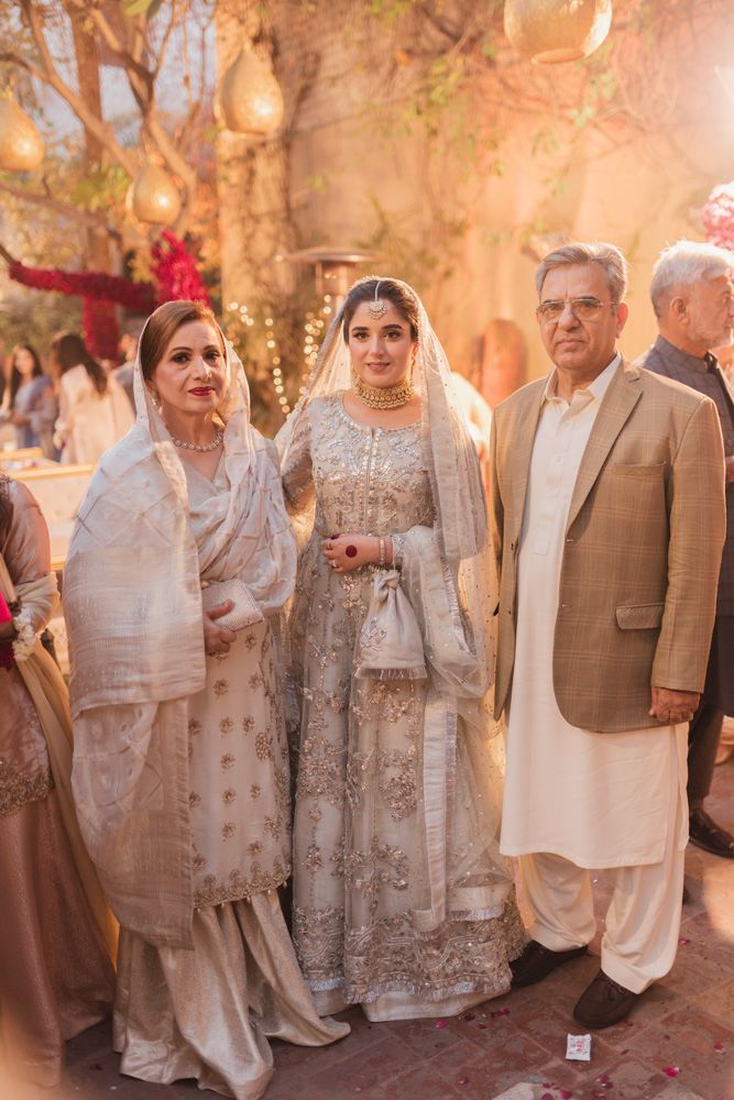 Bride posing with her parents in the haveli courtyard after the nikah, Ahmed & Laraib's wedding