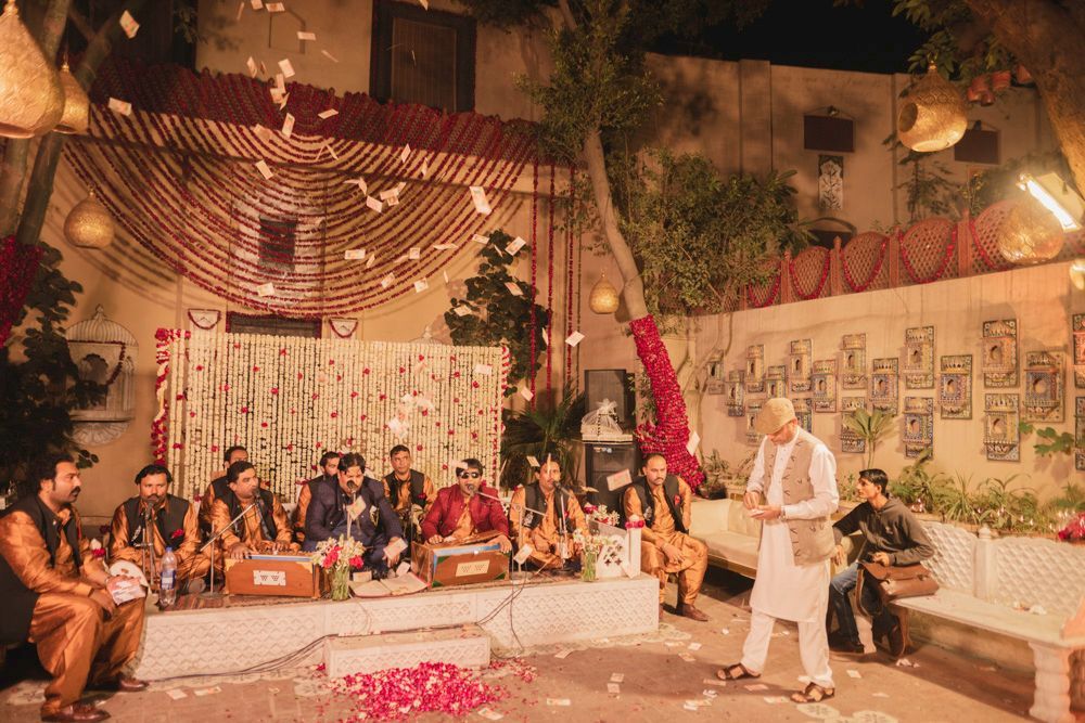 Qawwali musicians performing at night as money notes are showered over them, Ahmed & Laraib's wedding at Barood Khana Haveli, Lahore