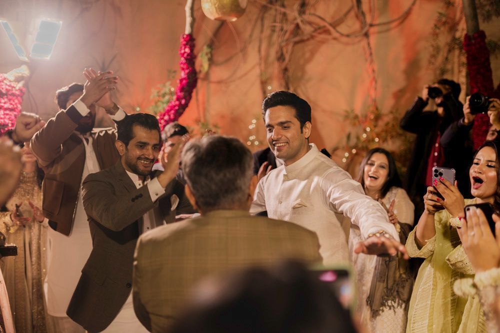 Groom dancing and laughing with guests at night during the celebration, Ahmed & Laraib's wedding