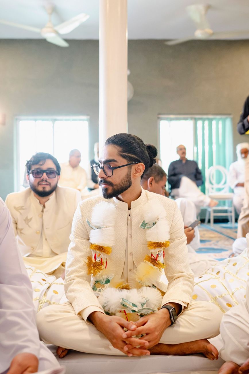 Groom seated for the nikah wearing a money garland, family members seated around him, Maham & Aurangzeb's wedding