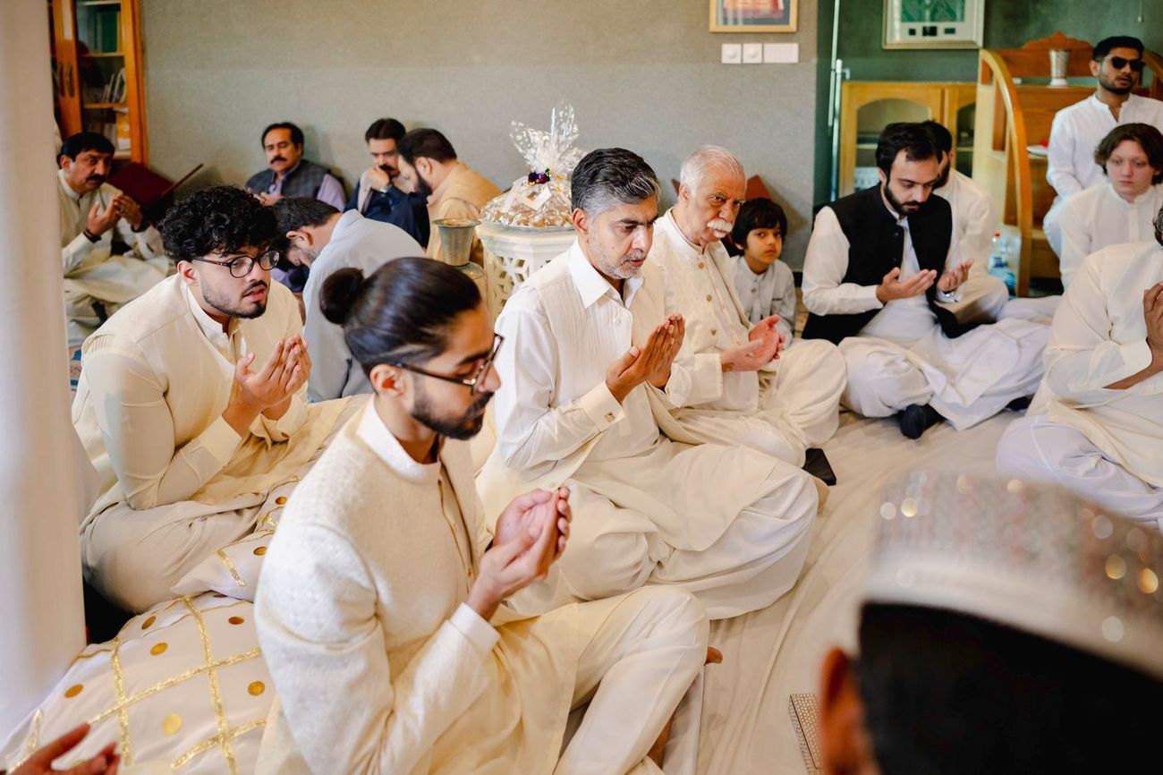 Male family members raising their hands in prayer after the nikah ceremony, Maham & Aurangzeb's wedding
