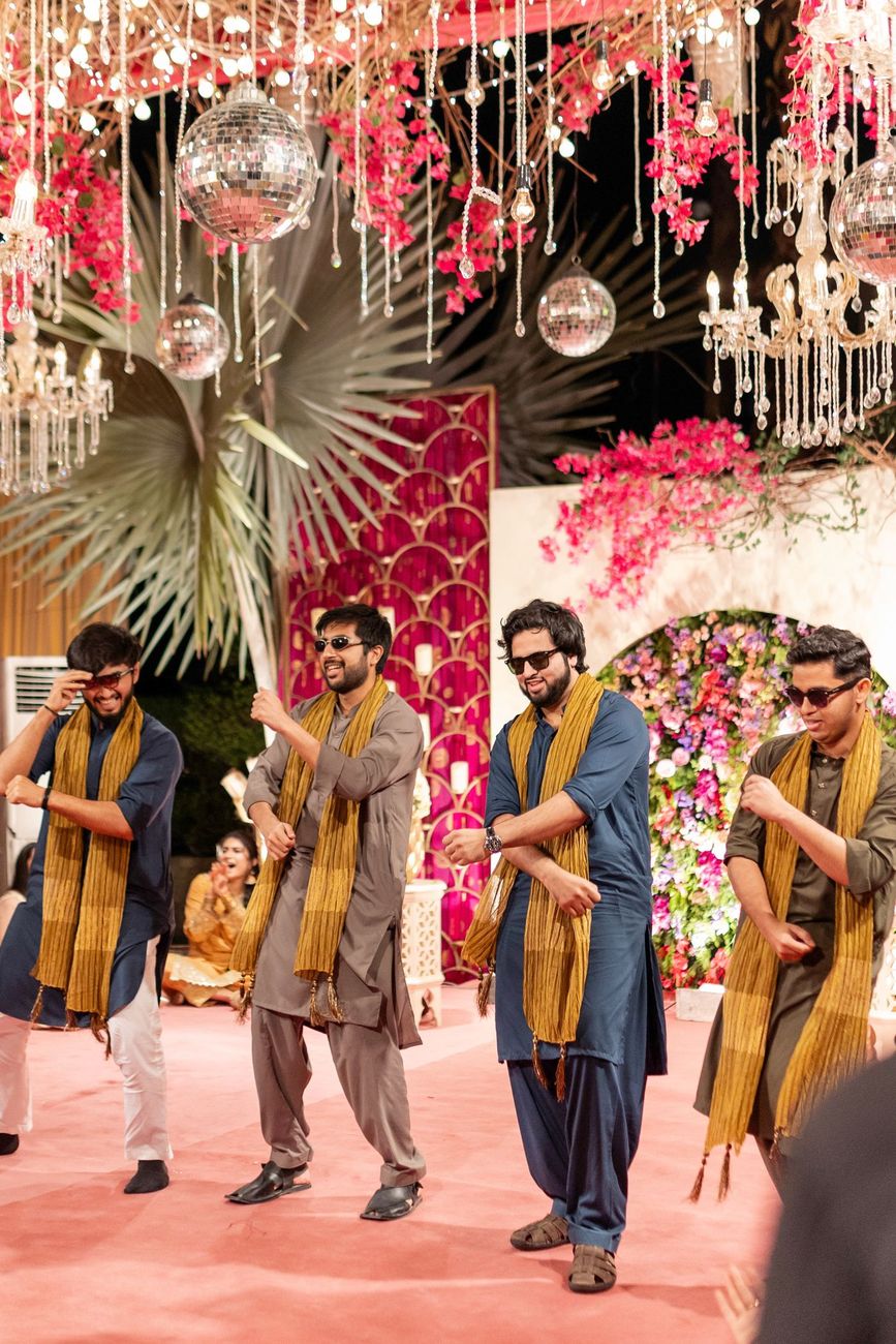 Groomsmen performing a synchronized dance number on the mehndi stage beneath disco balls, Maham & Aurangzeb's wedding