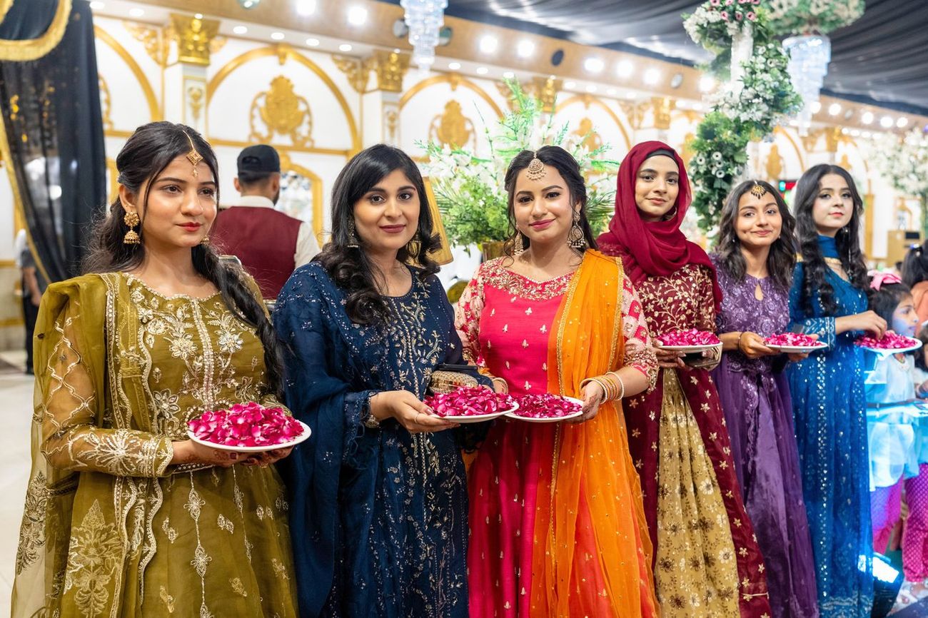 Family and friends holding plates of rose petals at the reception entrance, Maham & Aurangzeb's wedding