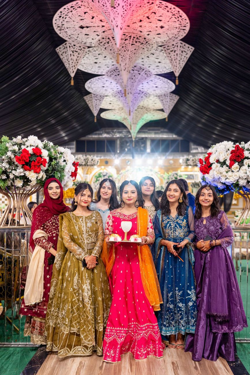 Group of friends posing together beneath decorative hanging lampshades at the reception, Maham & Aurangzeb's wedding
