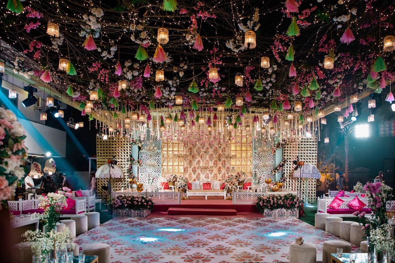 Wide shot of the empty mehndi stage decorated with colorful hanging tassels and lights, Mashal & Danial's wedding