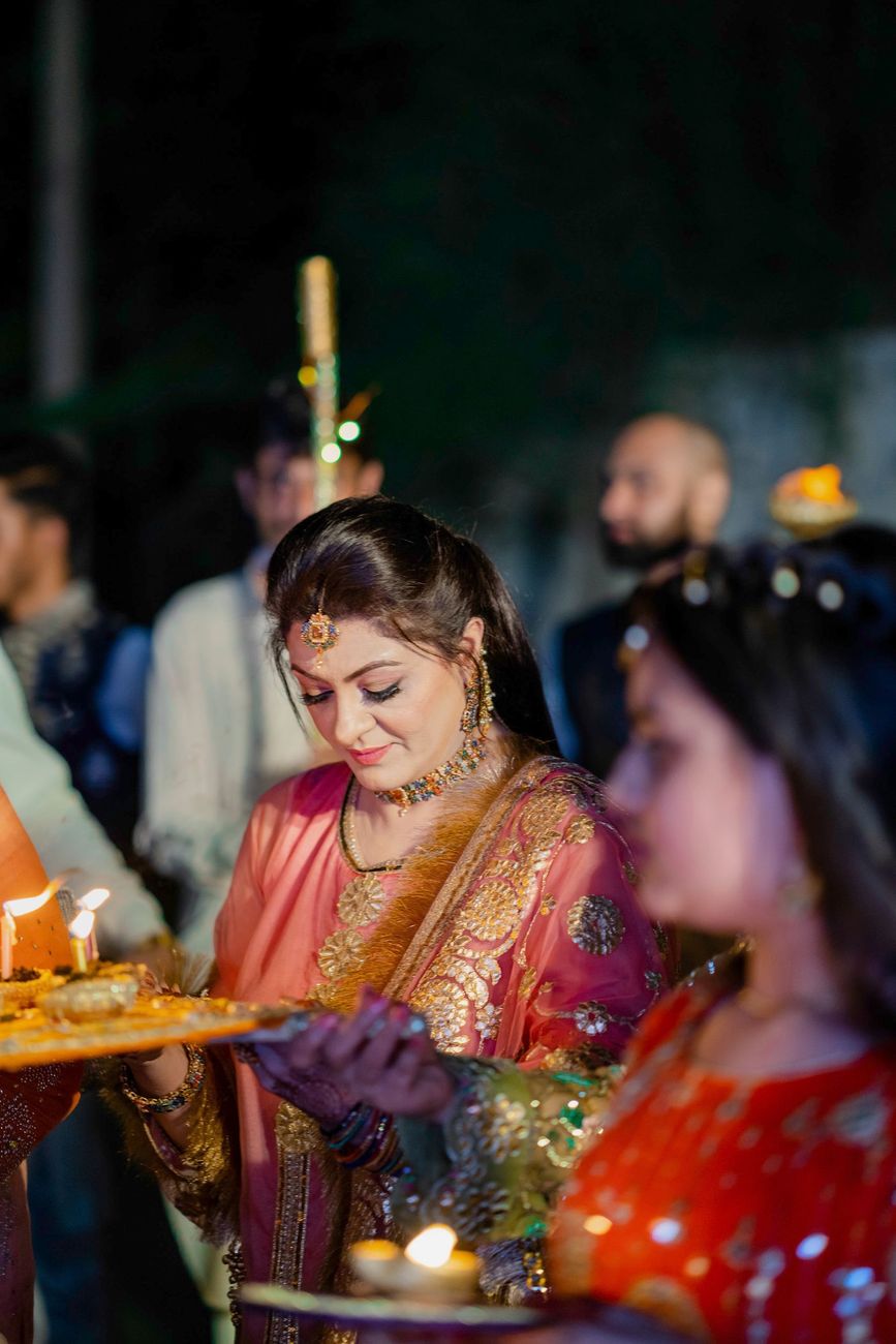 A family member holding a tray of lit candles during the mehndi ceremony, Mashal & Danial's wedding