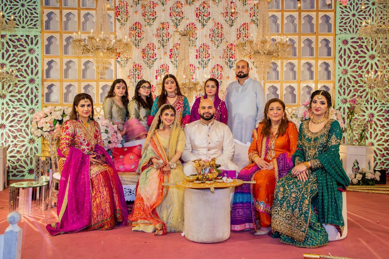 Extended family group portrait around the bride and groom on the mehndi stage, Mashal & Danial's wedding