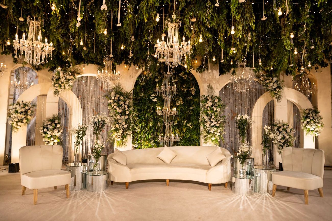 Wide shot of the empty reception lounge area framed by arched doorways and hanging greenery, Mashal & Danial's wedding