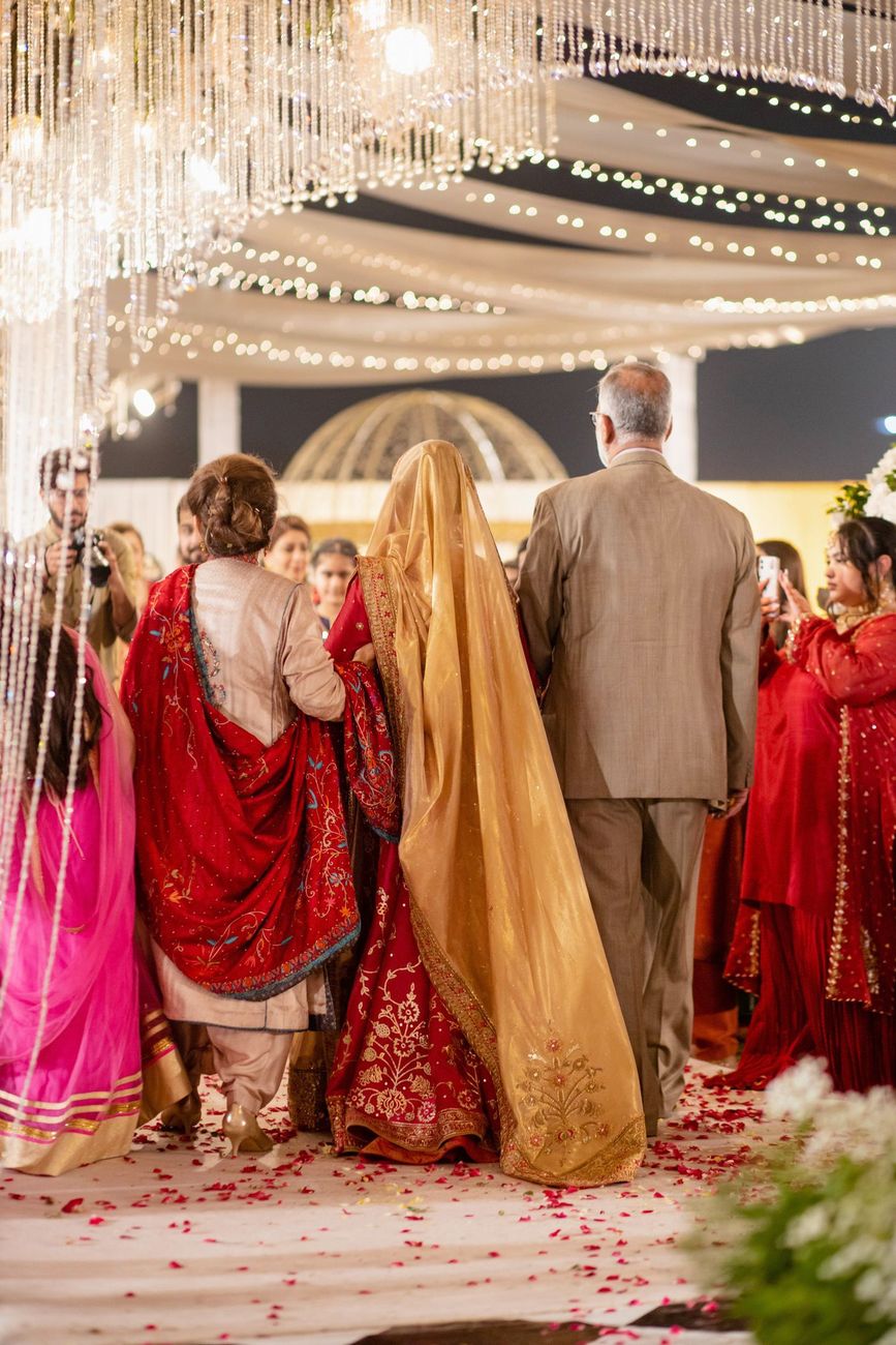 Bride's reception entrance viewed from behind, escorted by family beneath a domed pavilion, Mashal & Danial's wedding