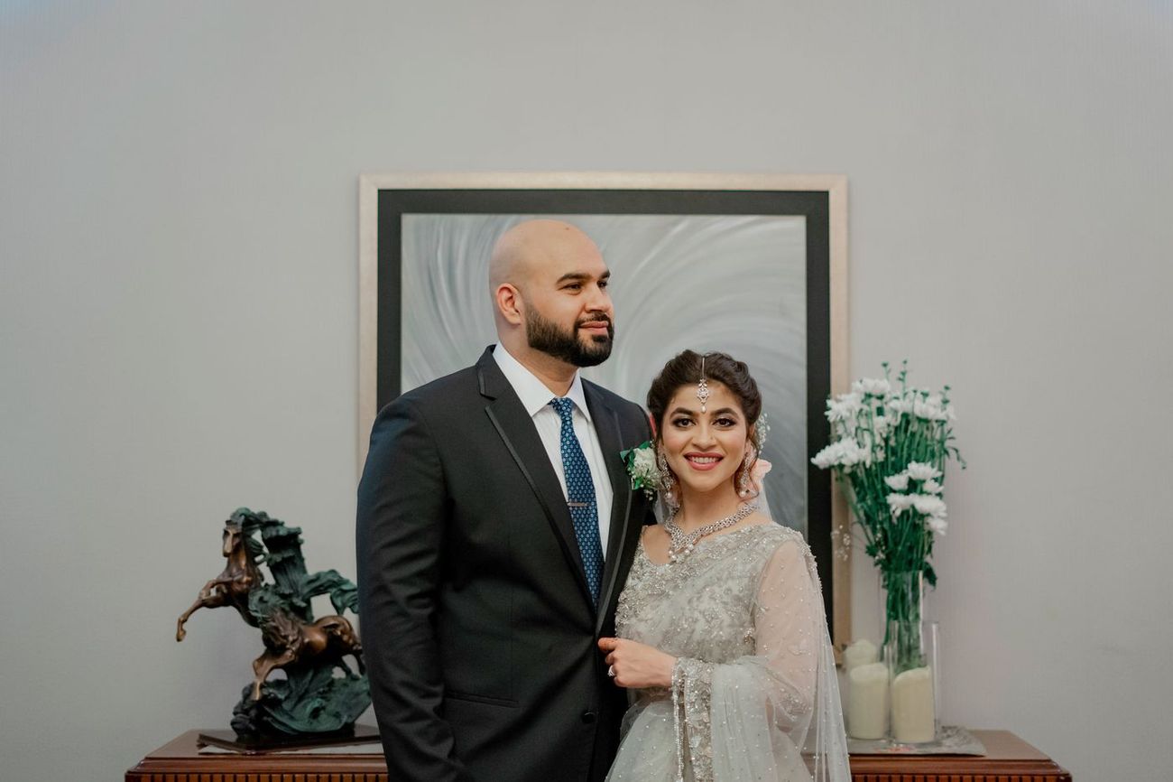 Bride and groom dancing together at the walima as guests and a photographer look on, Mashal & Danial's wedding