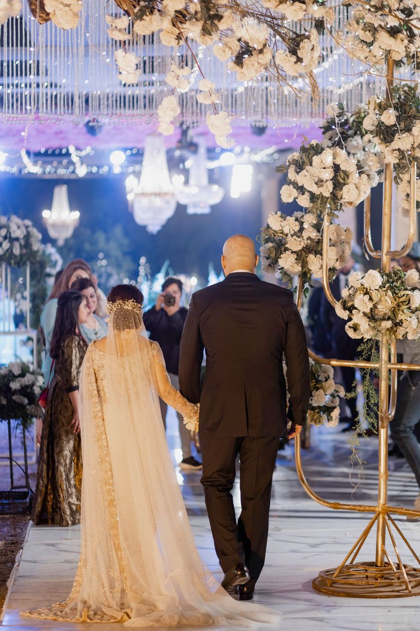 Bride and groom walking hand in hand toward the walima reception, viewed from behind, Mashal & Danial's wedding