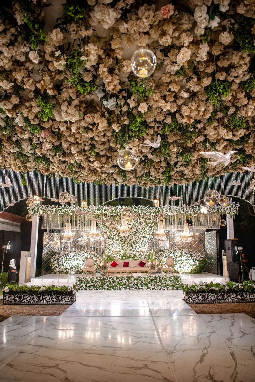 Wide shot of the empty walima stage covered in white roses with paper bird decorations, Mashal & Danial's wedding