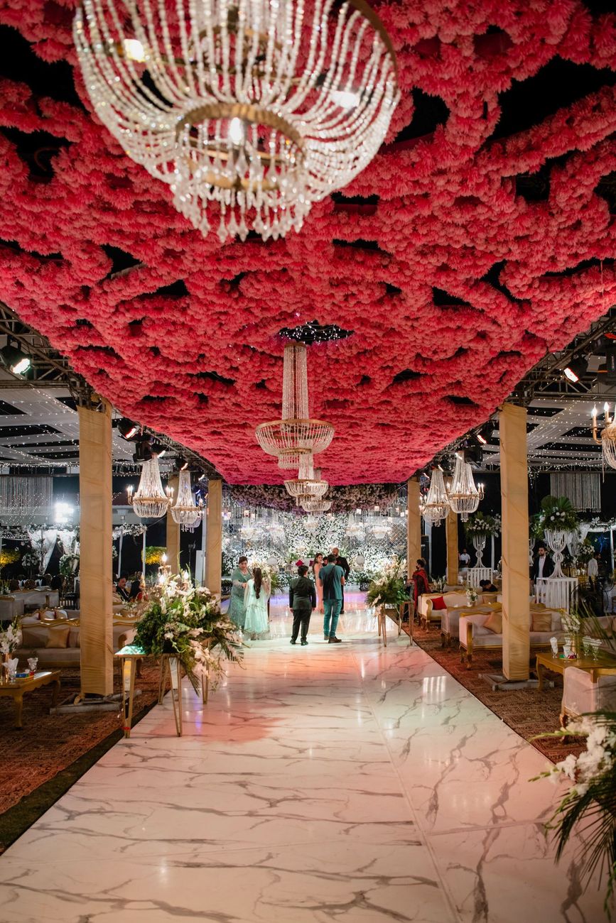 Wide night shot of the walima venue's pink ceiling installation and central aisle, Mashal & Danial's wedding