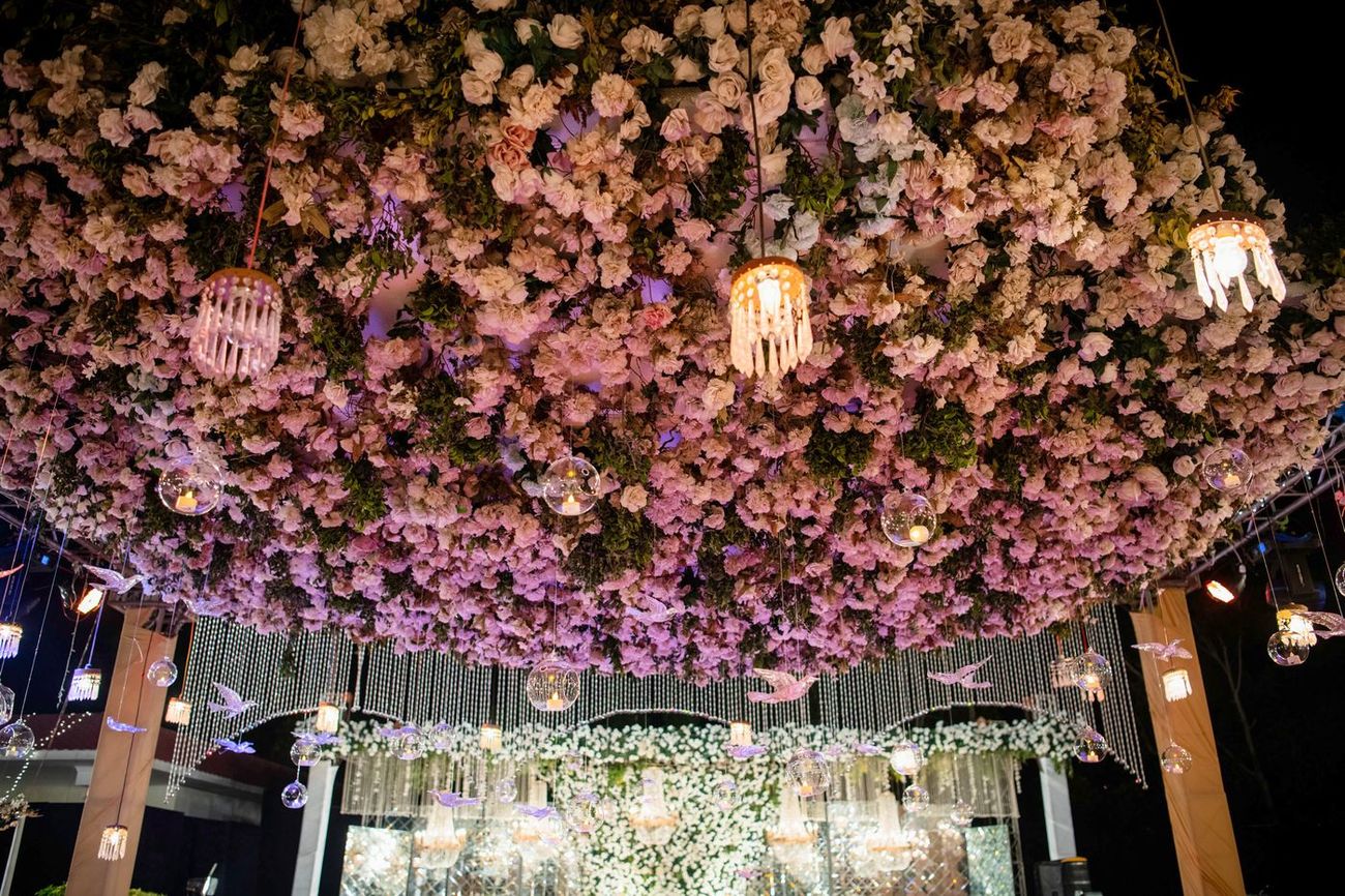 Detail of a pink and white floral ceiling installation with hanging crystal orbs at the walima, Mashal & Danial's wedding