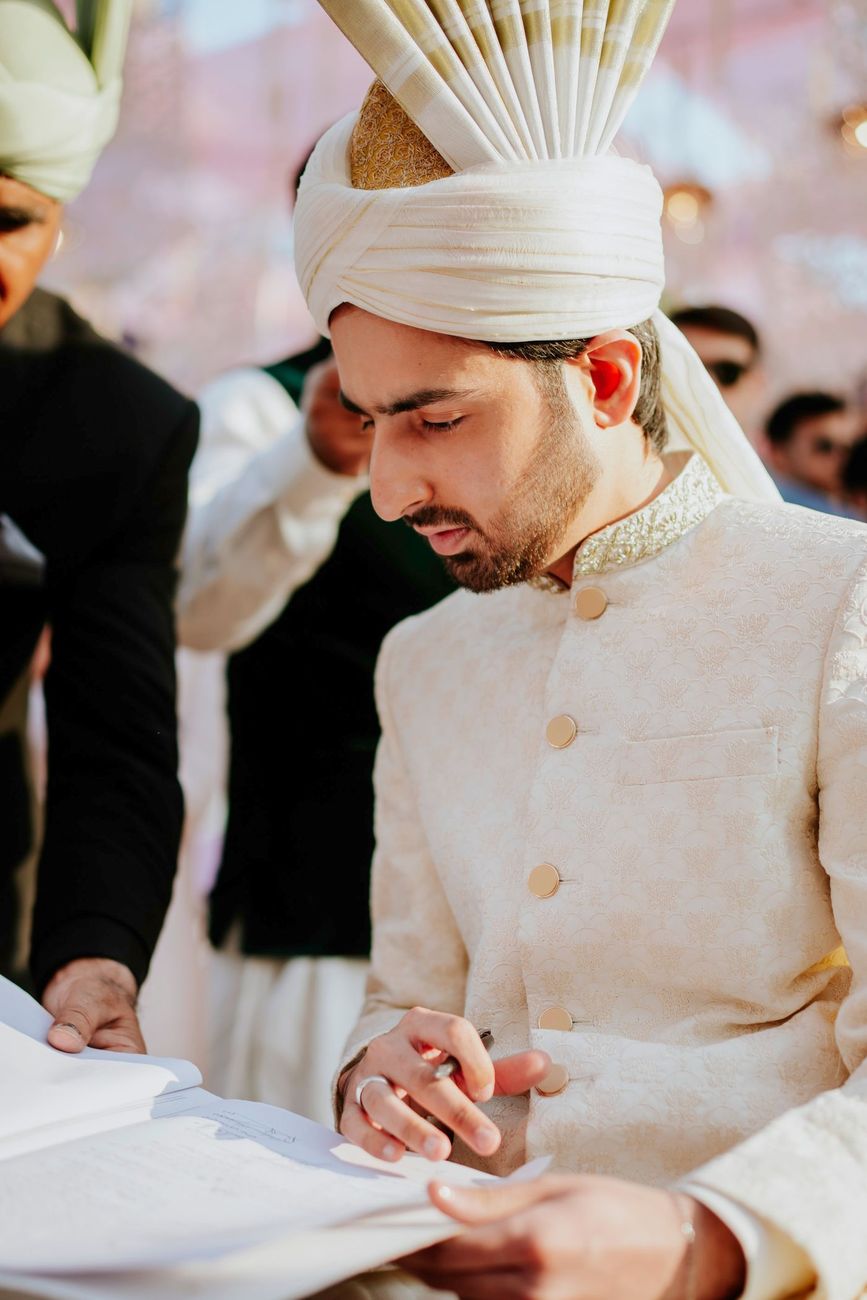 Close-up of the groom signing the nikah documents