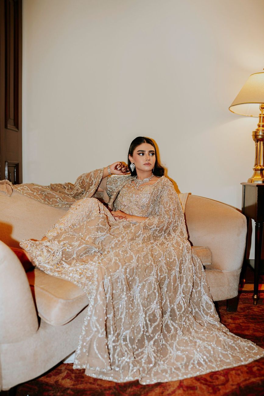 Solo bridal portrait reclining on a sofa in the hotel suite, looking off to the side