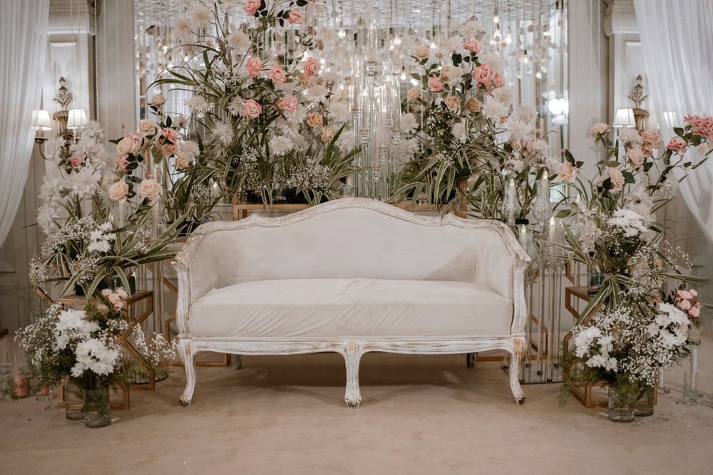 Wide shot of the white floral-draped lounge area on the reception stage, Sheraz & Nawal's wedding at Nishat Hotel, Lahore