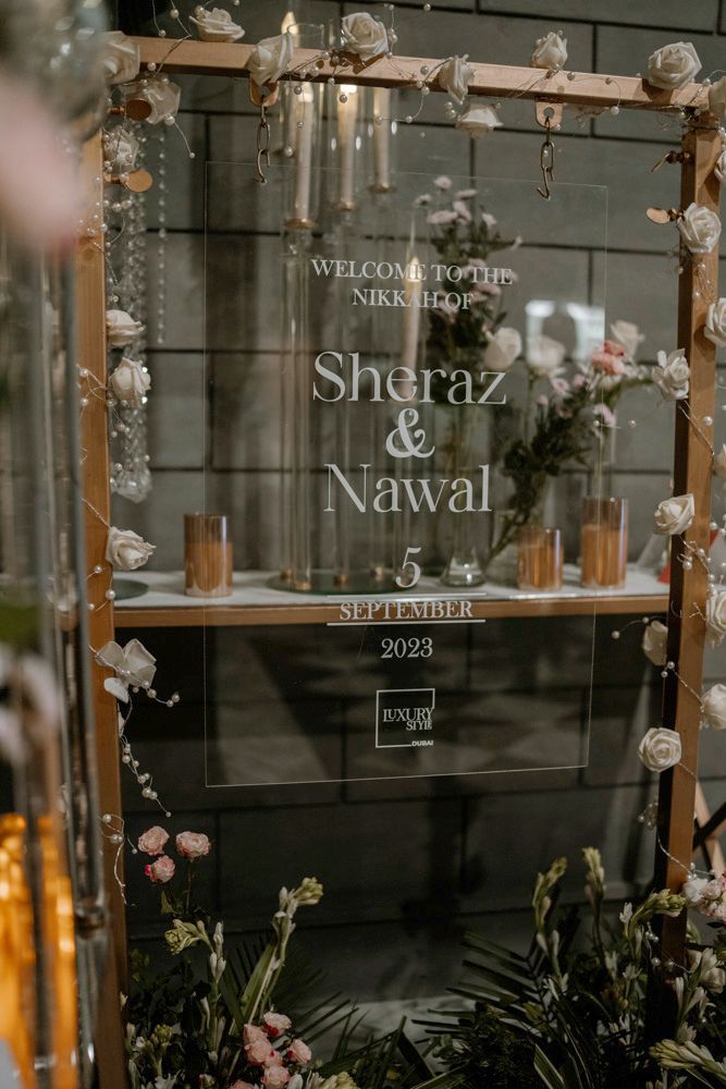 Welcome sign for the nikah of Sheraz and Nawal, dated 5 September 2023, displayed among white roses