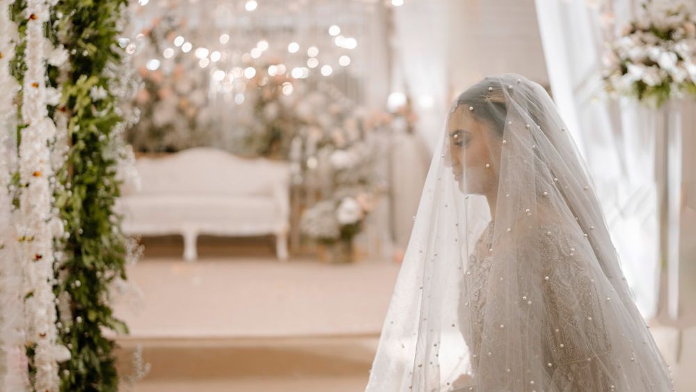 Bride beneath her veil walking toward the reception lounge area, Sheraz & Nawal's wedding at Nishat Hotel, Lahore