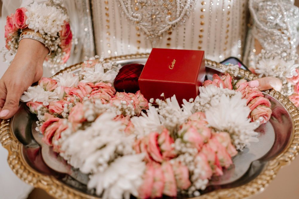 Detail of a red ring box on a tray surrounded by pink and white flower garlands, Sheraz & Nawal's wedding at Nishat Hotel, Lahore