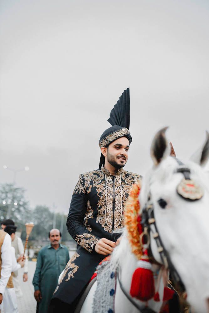 Groom riding the decorated white horse during the baraat procession, Zara & Shuaib's wedding, Lahore