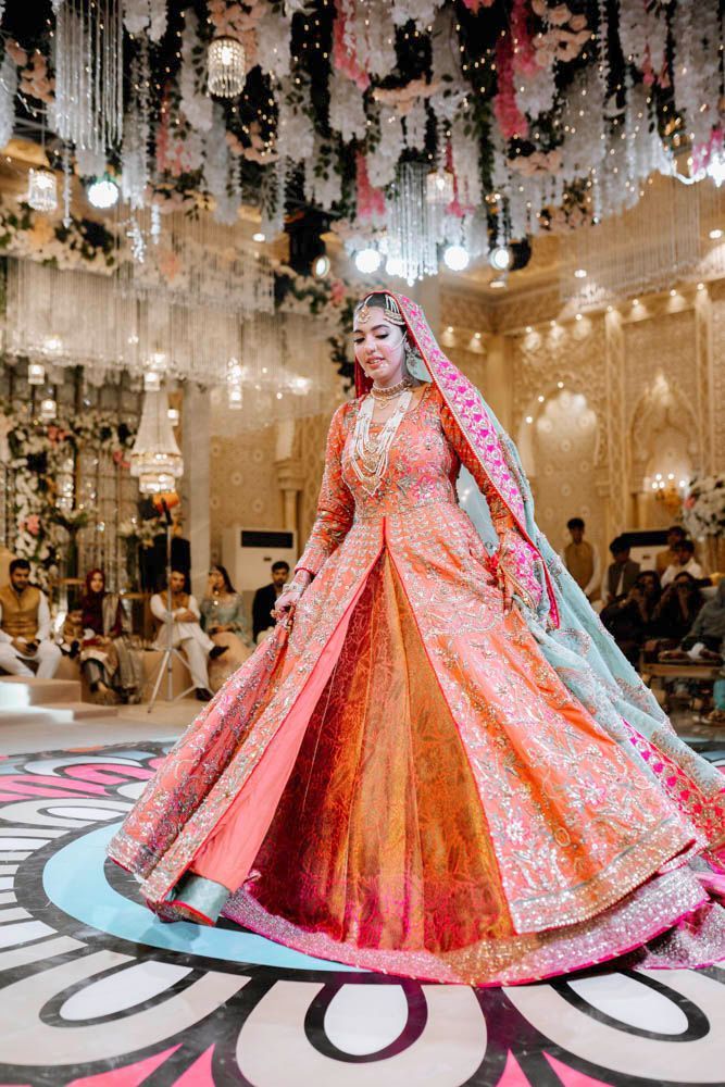 Bride mid-twirl on the dance floor, her coral lehenga flaring out, Zara & Shuaib's wedding at Garrison Halls, Lahore