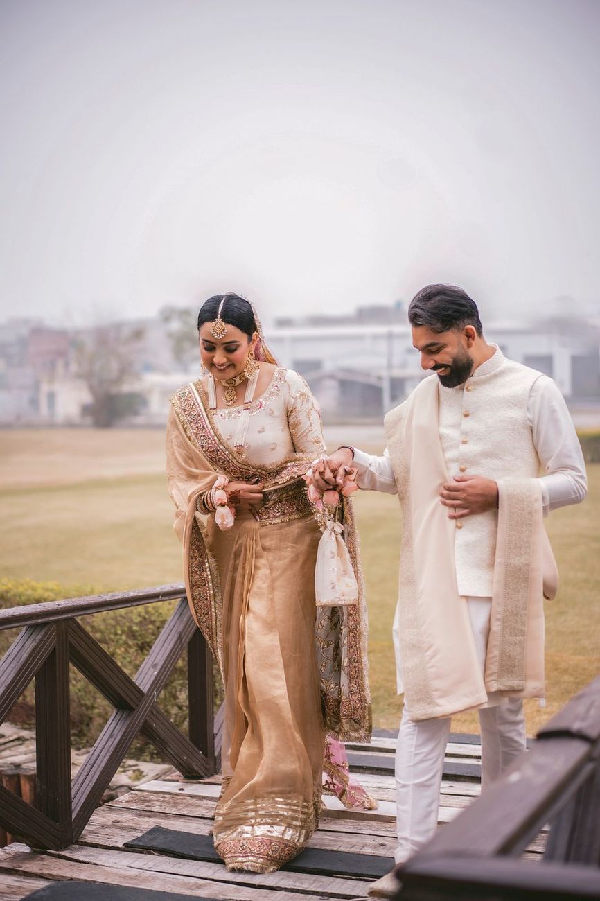 Couple walking together down wooden steps on a foggy outdoor terrace