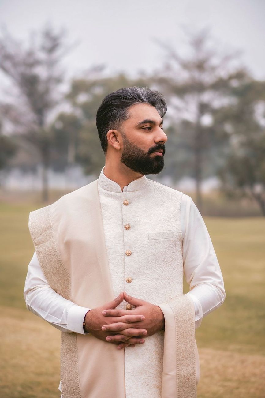Solo portrait of the groom looking off to the side on the misty hillside