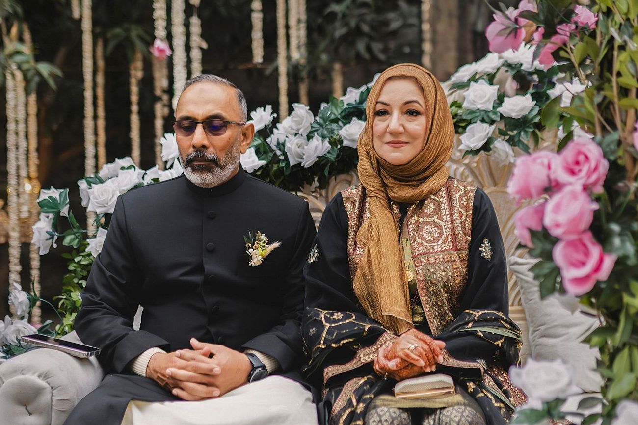 Solemn portrait of the groom's parents seated quietly during the ceremony