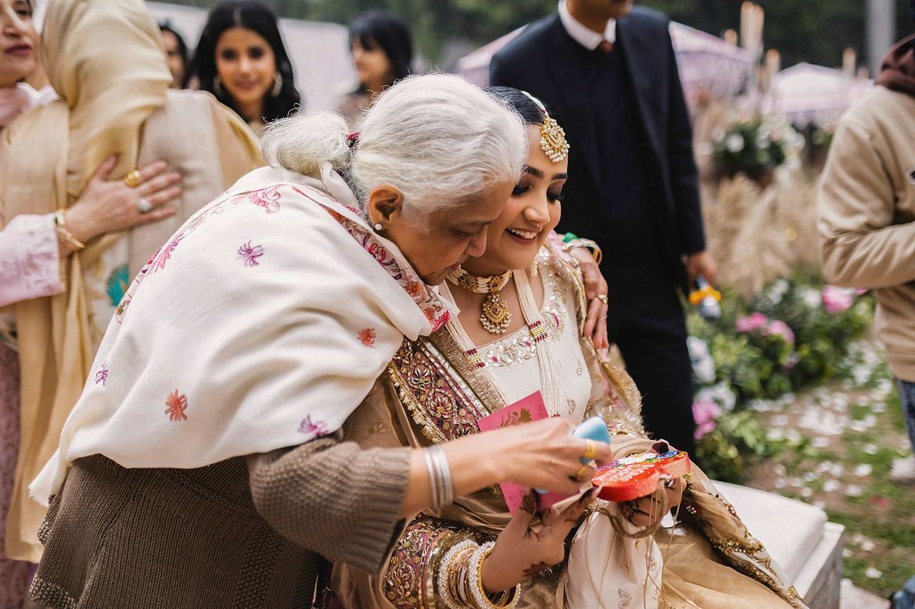 Bride affectionately blessed by an elderly woman, candid emotional moment