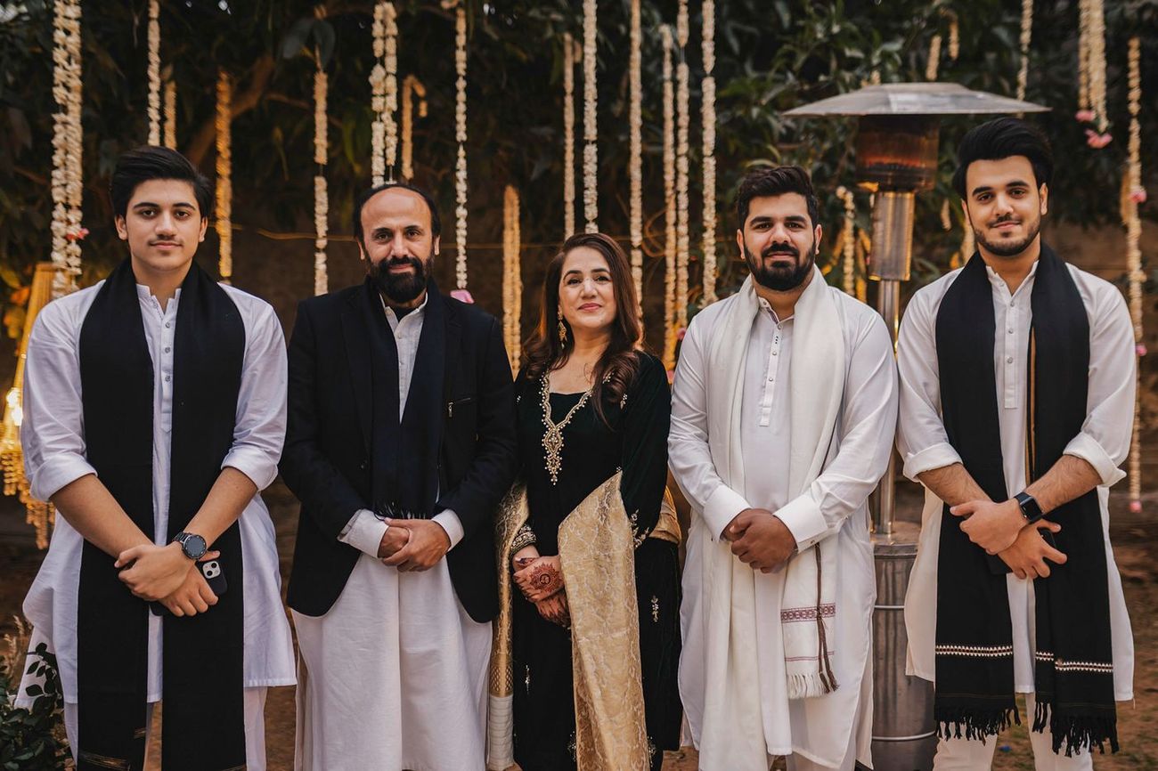 Groom with male friends and cousins, all in white and black, posed at the evening venue