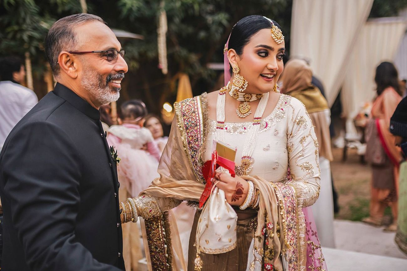Bride chatting and laughing with the groom's father, candid moment