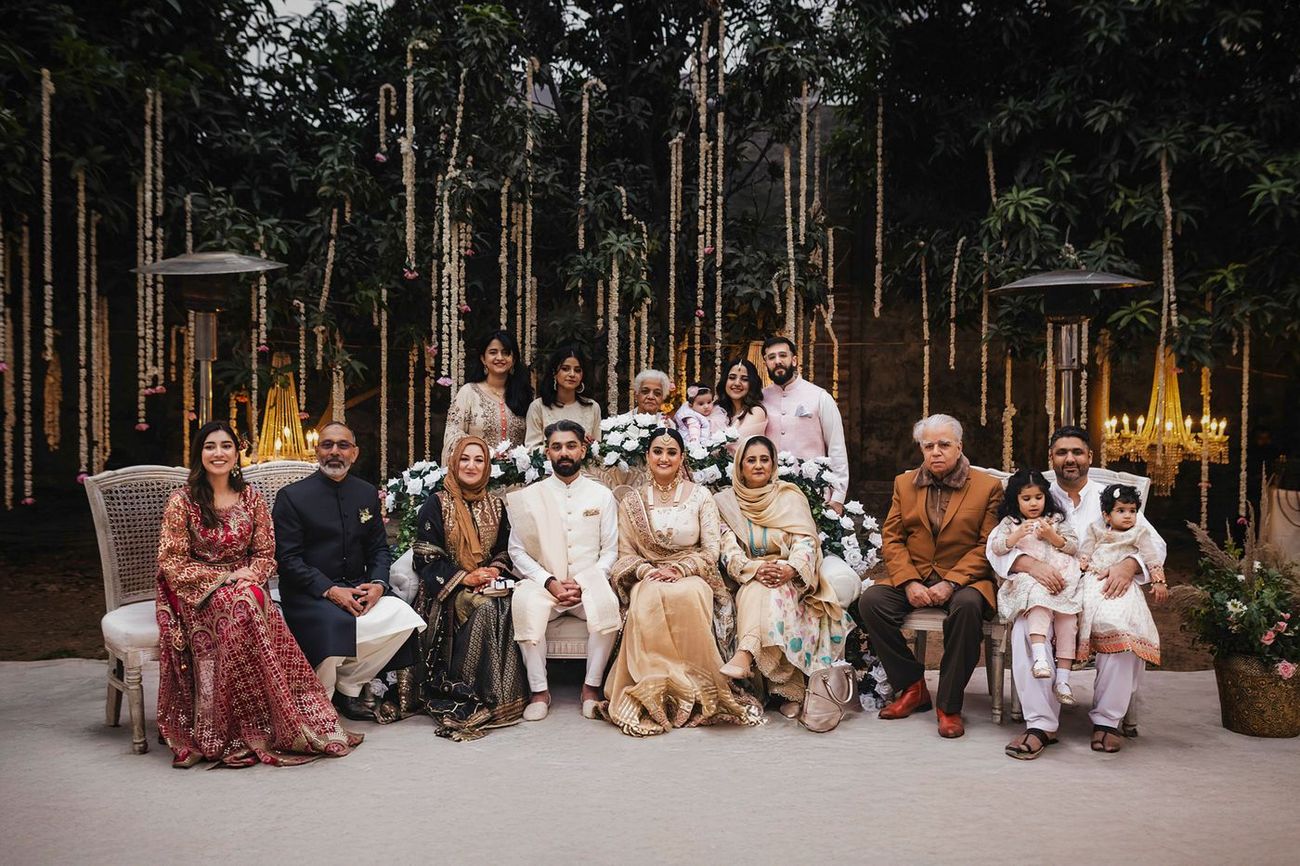Extended family group portrait with both sets of parents and relatives including small children