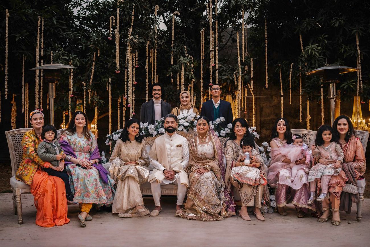 Larger group photo with cousins and small children gathered around the couple