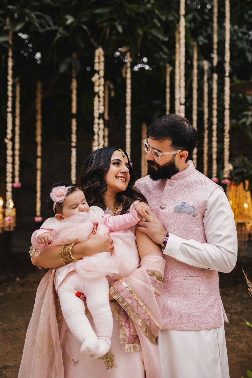 Family of guests in matching pink outfits, woman holding a baby