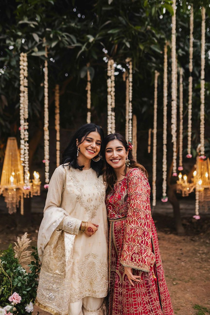 Two female guests posed together, candle decor in the background
